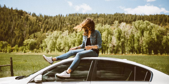 Girl Sitting on the Roof of the Car